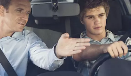 A man and boy in the back of a car.